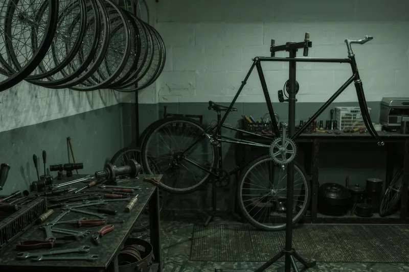 A small bike rental workshop with wheels hanging on the wall and a repair stand holding a bare frame.